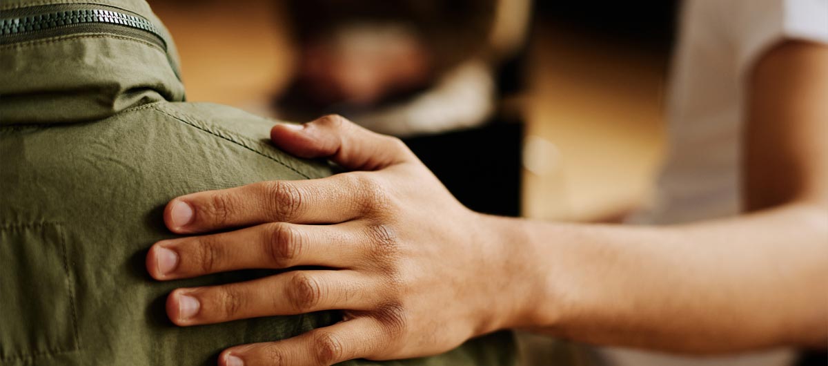 Woman putting her hand on a shoulder for support